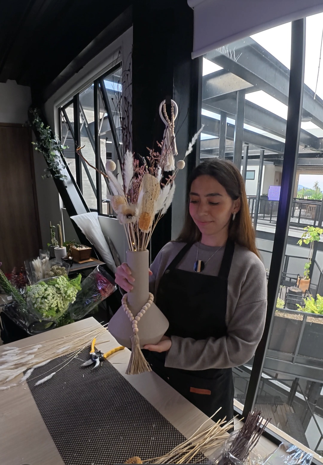 Gaby, florista experta de Atelier de GA, sosteniendo una composición preservada